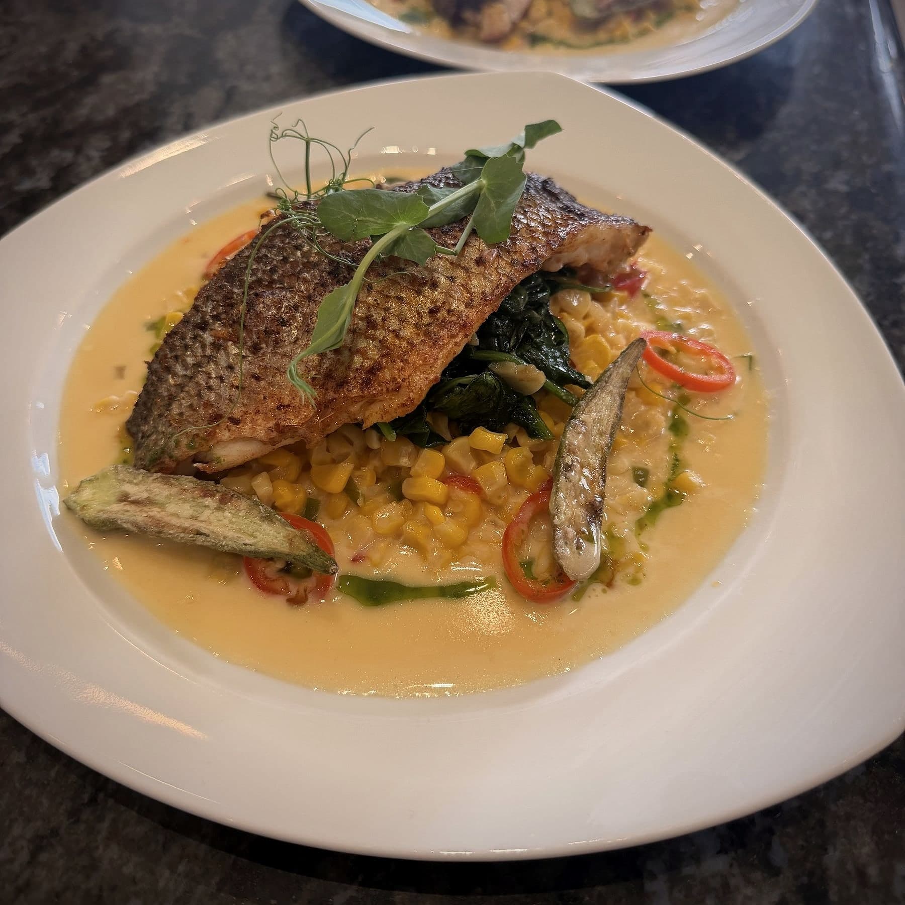 Chef Lauren Lawless's crispy-skin fish over sweet corn, wilted spinach and charred okra